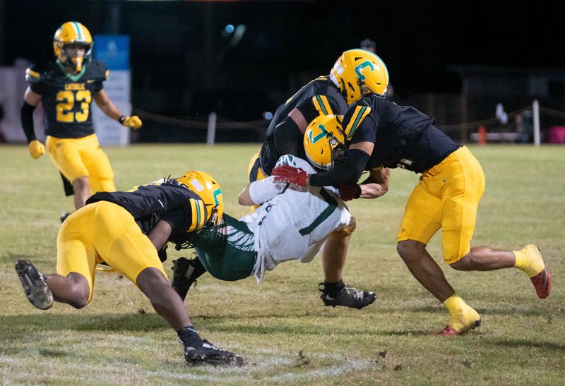 Three Crusaders converge to stop Seahawks Carter Hawk (7) as he carries the ball during the South Walton vs Pensacola Catholic 2A Regional Semifinals football game at Pensacola Catholic High School on Nov. 21, 2025.