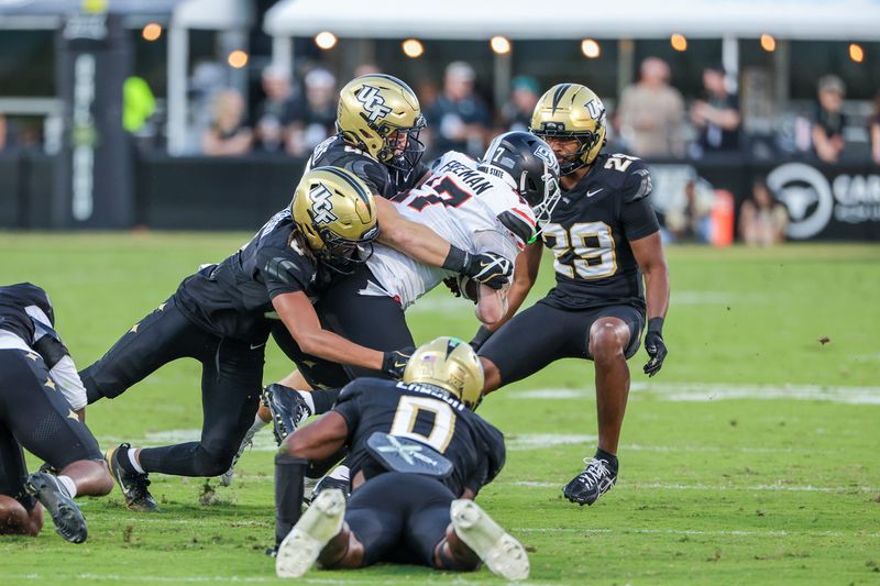 Nov 22, 2025; Orlando, Florida, USA; Oklahoma State Cowboys wide receiver Gavin Freeman (17) is tackled by UCF Knights linebacker Cole Kozlowski (43) during the second quarter at Acrisure Bounce House. Mandatory Credit: Mike Watters-Imagn Images