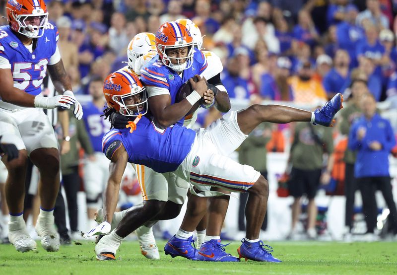 Nov 22, 2025; Gainesville, Florida, USA; Florida Gators quarterback DJ Lagway (2) runs into Florida Gators wide receiver TJ Abrams (4) as he runs with the ball and Tennessee Volunteers defensive lineman Tyre West (42) defends during the second half at Ben Hill Griffin Stadium. Mandatory Credit: Kim Klement Neitzel-Imagn Images