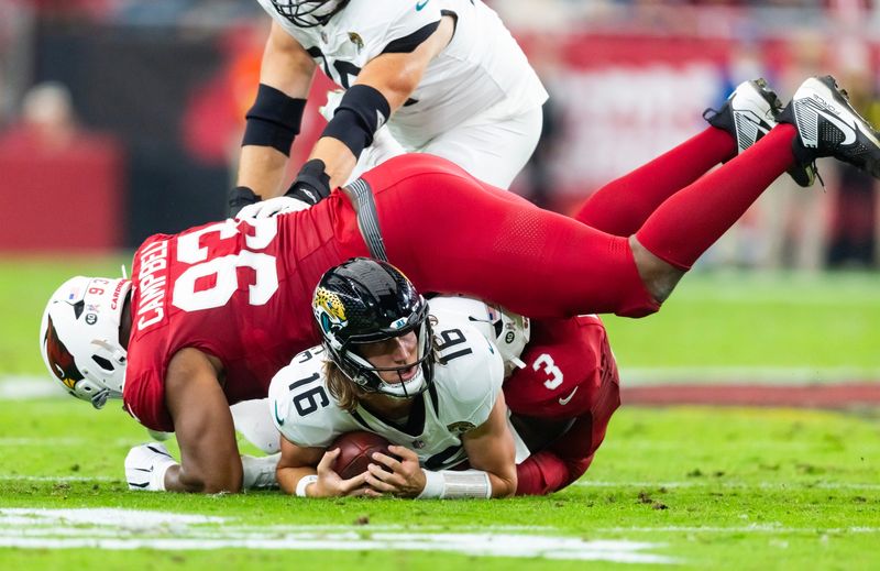 Nov 23, 2025; Glendale, Arizona, USA; Jacksonville Jaguars quarterback Trevor Lawrence (16) is tackled by Arizona Cardinals defensive lineman Calais Campbell (93) in the first half at State Farm Stadium. Mandatory Credit: Mark J. Rebilas-Imagn Images