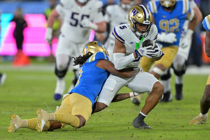 Nov 22, 2025; Pasadena, California, USA; UCLA Bruins defensive back Kanye Clark (1) stops Washington Huskies wide receiver Omari Evans (5) after a complete pass during the first half at the Rose Bowl. Mandatory Credit: Jayne Kamin-Oncea-Imagn Images