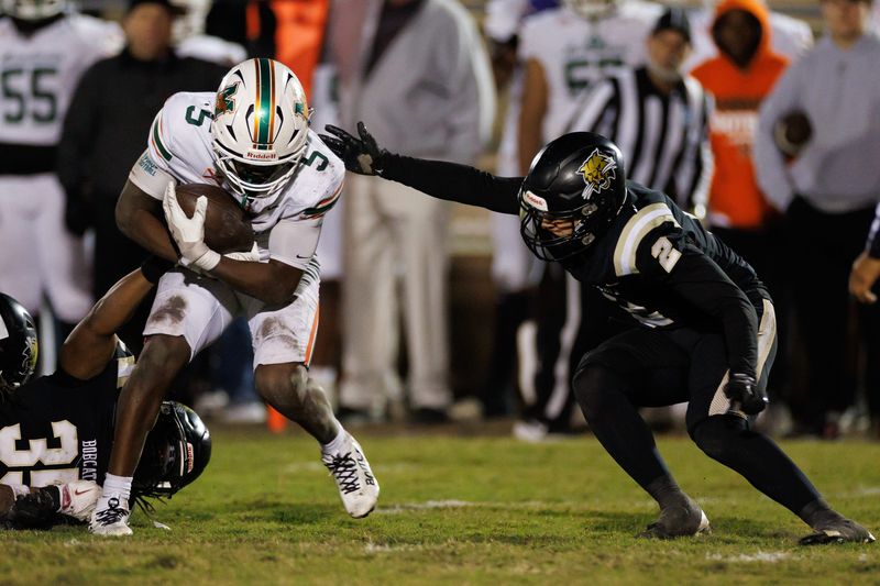 Buchholz Bobcats linebacker Zay Robinson (35) and Buchholz Bobcats defensive back Troy Fleming (2) tackle Mandarin Mustangs running back Shaunqueze Foster (5) during the second half at the 2025 FHSAA Football State Championships 6A Regional Finals at Citizens Field in Gainesville, FL on Friday, November 28, 2025. [Matt Pendleton/Gainesville Sun]