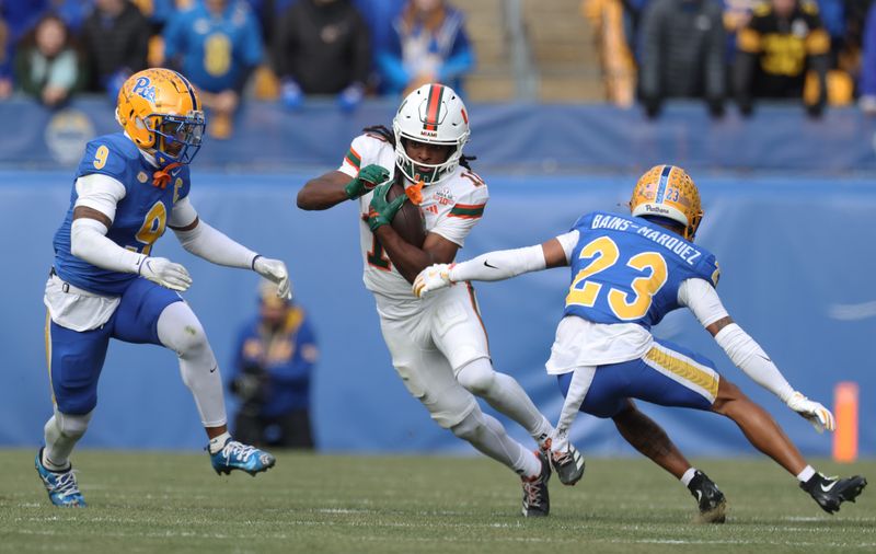 Miami Hurricanes wide receiver Malachi Toney (10) runs after a catch as Pittsburgh Panthers linebacker Kyle Louis (9) and safety Kavir Bains-Marquez (23) chase during the first quarter Nov. 29, 2025 at Acrisure Stadium in Pittsburgh, Pennsylvania.