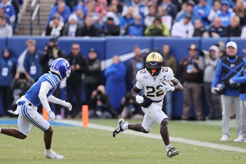 Nov 29, 2025; Provo, Utah, USA; UCF Knights running back Myles Montgomery (22) runs against BYU Cougars safety Raider Damuni (3) during the second half at LaVell Edwards Stadium. Mandatory Credit: Rob Gray-Imagn Images