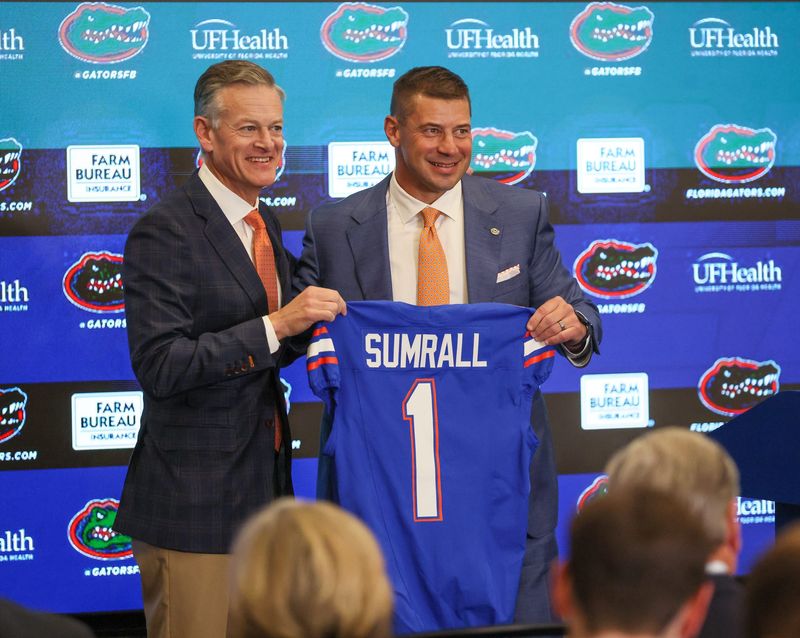 UF Athletic Director Scott Stricklin and new UF head football coach Jon Sumrall pose with a jersey at a press conference James W. “Bill” Heavener Football Training Center in Gainesville, FL on Monday, December 1, 2025. [Alan Youngblood/Gainesville Sun]