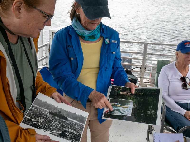 LuAnne Warren and Capt. Karen Chadwick look over historic pictures of the Ocklawaha River during a Great Florida Riverway Trust tour of the drawn-down Rodman Reservoir on Dec. 5, 2025.