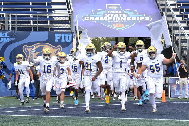 Cardinal Newman players rush the field upon being announced prior to the Class 1A state championship game against Chaminade Madonna on Dec. 11, 2025.