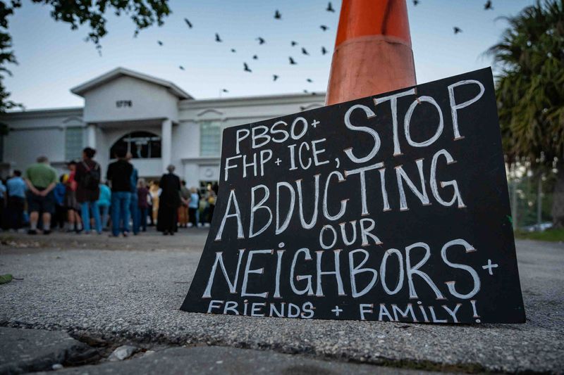 Signage at a prayer vigil at the Guatemalan-Maya Center in Lake Worth Beach  on Dec. 11, 2025, after ICE agents recently raided construction sites in and around Lake Worth Beach, detaining a number of people.