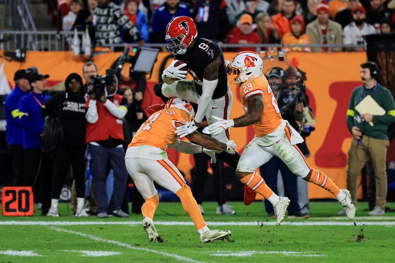Dec 11, 2025; Tampa, Florida, USA; Atlanta Falcons tight end Kyle Pitts Sr. (8) is tackled by Tampa Bay Buccaneers safeties Antoine Winfield Jr. (31) and Christian Izien (29) after catching a pass during the second quarter at Raymond James Stadium. Mandatory Credit: Kim Klement Neitzel-Imagn Images
