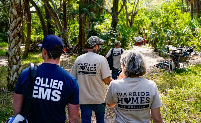 Warrior Homes of Collier members Greg Tinsley, center, Bob Evans, front, and Britten Grayden, right, walk with Collier EMS Lt. Corey Todd to check an encampment during the Southwest Florida Regional Coalition to End Homelessness' point-in-time count in east Naples, Fla., on Friday, Jan. 31, 2025.