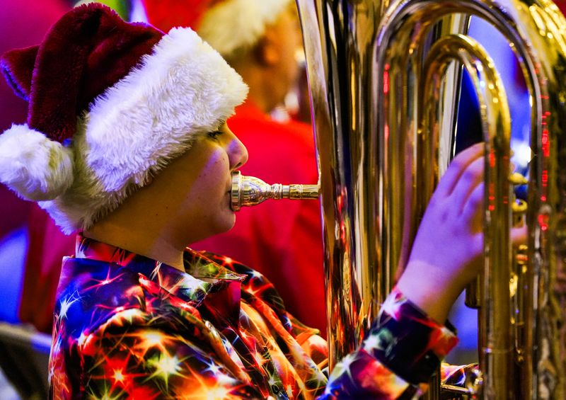 Hundreds of people gather to listen and watch the annual Tuba Christmas brass concert at Sugden Plaza in Naples, Fla., on Friday, Dec. 12, 2025.