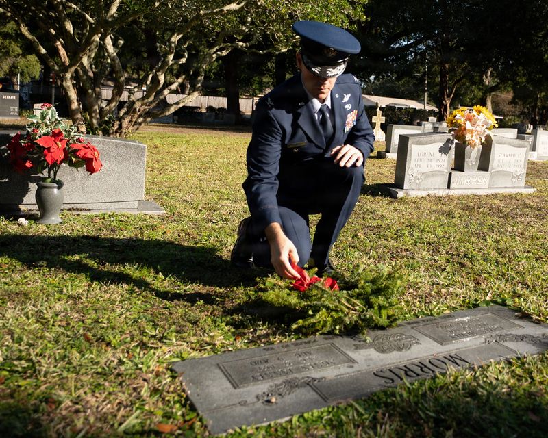 U.S. Air Force Col. Brian Taylor, 96th Test Wing deputy commander, lays a wreath by a gravestone memorial during the Wreaths Across America placement ceremony Dec. 13, 2025, at Beal Memorial Cemetery. This was the seventh year veterans buried at Beal received wreaths. (U.S. Air Force photo by Michelle Gigante)