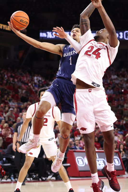 Dec 16, 2025; Fayetteville, Arkansas, USA; Queens Royals guard Nasir Mann (1) shoots as Arkansas Razorbacks wing Billy Richmond III (24) defends during the first half at Bud Walton Arena. Mandatory Credit: Nelson Chenault-Imagn Images