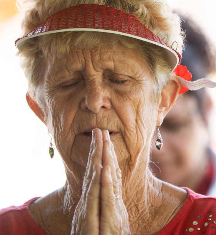 Nancy Bright prays while taking part in a Memorial Day ceremony at Hodges Funeral Home at Naples Memorial Garden on Monday, May 26, 2025. The event featured a flyover, speakers, flag folding & presentation, a wreath ceremony and a reading of the list of our fallen service members among other things.