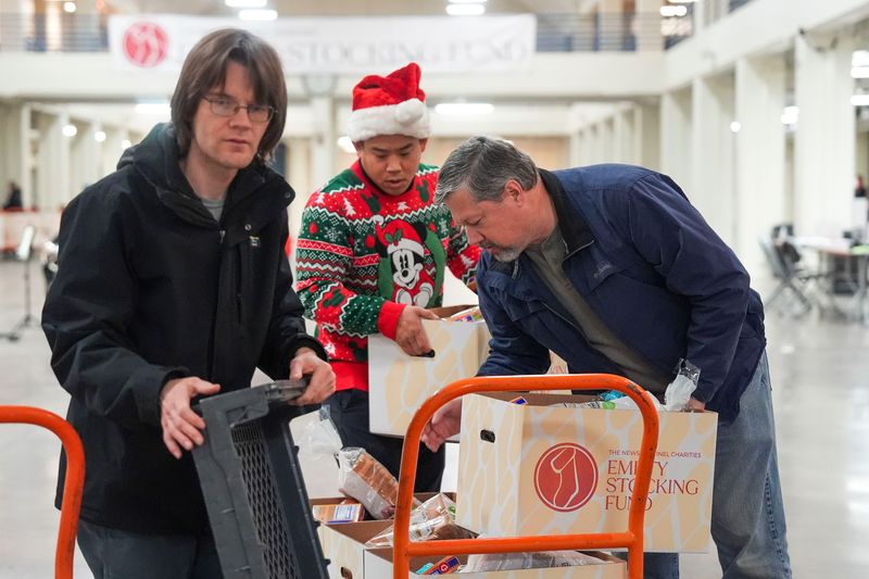Volunteers organize boxes during distribution day for the News Sentinel Charities' Empty Stocking Fund at the Jacob Building at Chilhowee Park in East Knoxville on Dec. 20, 2025.