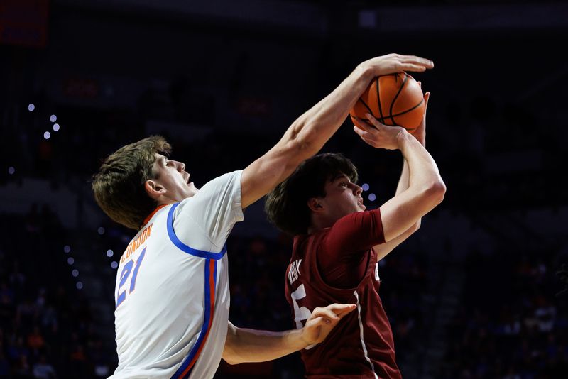 Dec 21, 2025; Gainesville, Florida, USA; Florida Gators forward Alex Condon (21) blocks a shot from Colgate Raiders guard Ben Tweedy (6) during the first half at Exactech Arena at the Stephen C. O'Connell Center. Mandatory Credit: Matt Pendleton-Imagn Images