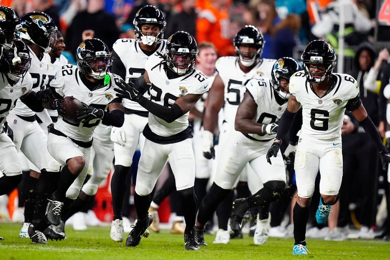 Dec 21, 2025; Denver, Colorado, USA; Jacksonville Jaguars cornerback Jarrian Jones (22) reacts after a turnover against the Denver Broncos during the second half at Empower Field at Mile High. Mandatory Credit: Ron Chenoy-Imagn Images
