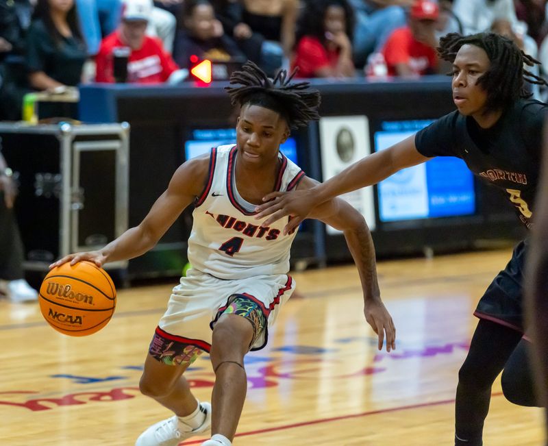Vanguard guard Cayden Croskey (4) drives past North Marion guard Edward Law III (5) during the annual Kingdom of the Sun tournament at Vanguard High school in Ocala, FL on Friday, December 26, 2025. North Marion beat Vanguard 40-33. [Alan Youngblood/Ocala Star-Banner]