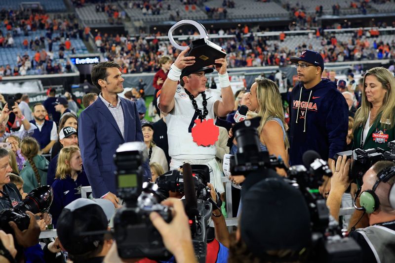 Virginia Cavaliers quarterback Chandler Morris (4) holds up the MVP trophy after the game of the TaxSlayer Gator Bowl at EverBank Stadium, Saturday, Dec. 27, 2025, in Jacksonville. Fla. Virginia defeated the Missouri 13-7. [Corey Perrine/Florida Times-Union]