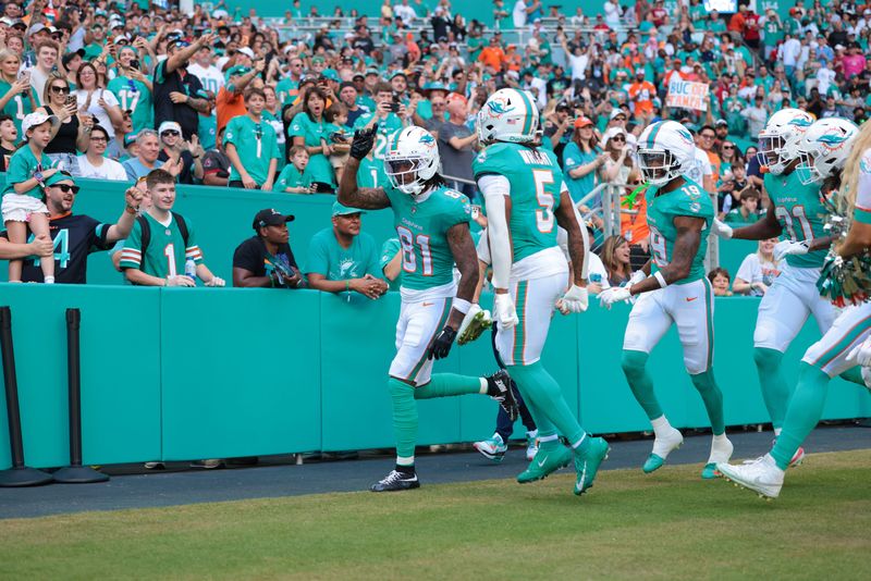 Dec 28, 2025; Miami Gardens, Florida, USA; Miami Dolphins wide receiver Theo Wease Jr. (81) celebrates with teammates after scoring a touchdown during the first quarter against the Tampa Bay Buccaneers at Hard Rock Stadium. Mandatory Credit: Sam Navarro-Imagn Images