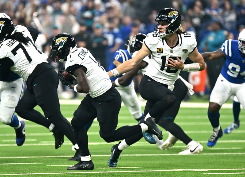 Dec 28, 2025; Indianapolis, Indiana, USA; Jacksonville Jaguars quarterback Trevor Lawrence (16) hands off to running back Travis Etienne Jr. (1) during the first half against the Indianapolis Colts at Lucas Oil Stadium. Mandatory Credit: Robert Goddin-Imagn Images
