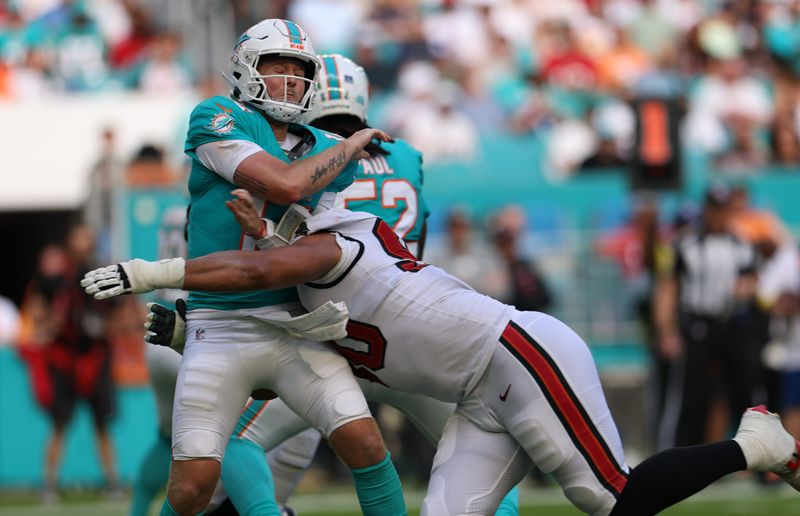 Dec 28, 2025; Miami Gardens, Florida, USA; Miami Dolphins quarterback Quinn Ewers (14) is hit by Tampa Bay Buccaneers defensive end Logan Hall (90) after throwing downfield during the third quarter
at Hard Rock Stadium. Mandatory Credit: Nathan Ray Seebeck-Imagn Images