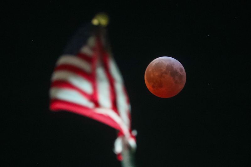 A total lunar eclipse, known as a Blood Moon, can be seen glows red over Savannah City Hall on Friday, March 14, 2025