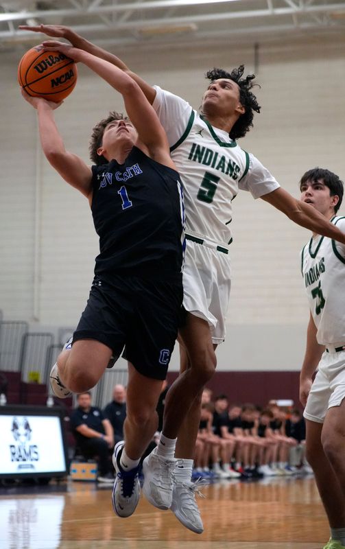 Venice’s Giulio Leon (#5) blocks a shot attempt by Covington Catholic’s Athens McGillis (#1). The Venice High School Indians took on the Covington Catholic High School Colonels in the championship game of the Ram Jam Holiday Classic basketball tournament Tuesday evening, Dec. 30, 2025, hosted by Riverview High School in Sarasota, Florida.