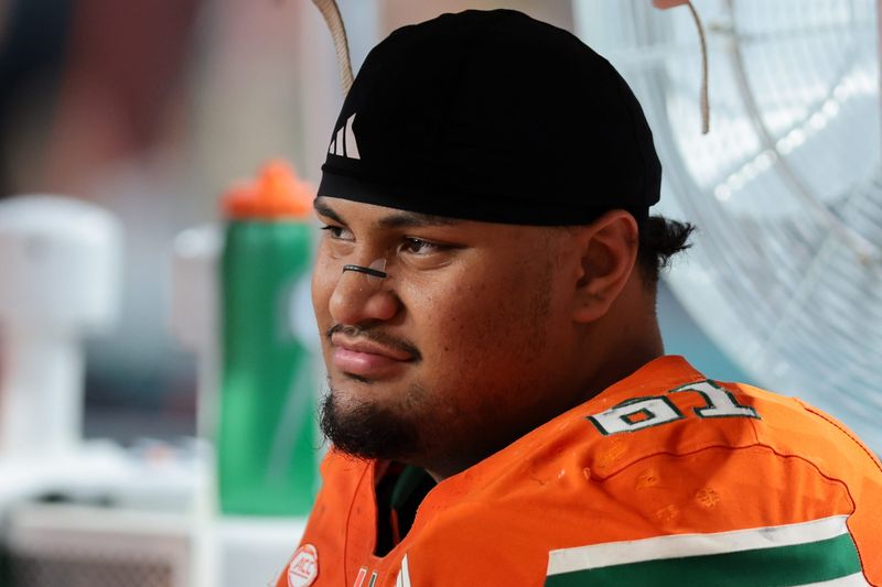 Nov 15, 2025; Miami Gardens, Florida, USA; Miami Hurricanes offensive lineman Francis Mauigoa (61) watches from the bench against NC State Wolfpack during the third quarter at Hard Rock Stadium. Mandatory Credit: Sam Navarro-Imagn Images