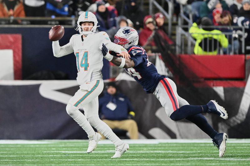 Jan 4, 2026; Foxborough, Massachusetts, USA; Miami Dolphins quarterback Quinn Ewers (14) scrambles against New England Patriots linebacker K'Lavon Chaisson (44) during the fourth quarter at Gillette Stadium. Mandatory Credit: Brian Fluharty-Imagn Images