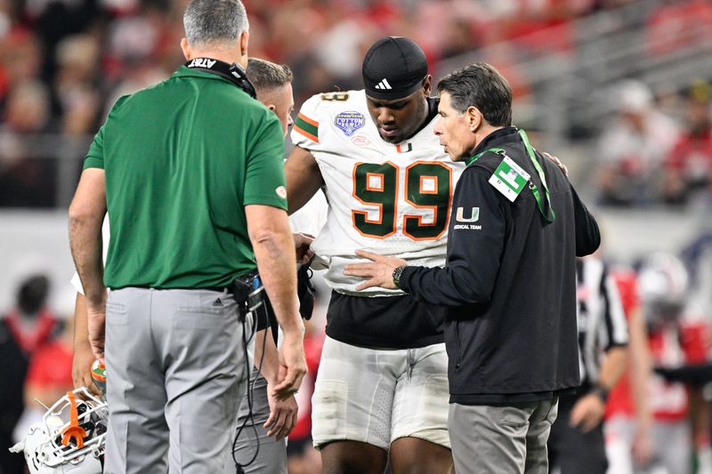 Dec 31, 2025; Arlington, TX, USA; Miami Hurricanes defensive line Ahmad Moten Sr. (99) is helped off the field during the third quarter against the Ohio State Buckeyes during the 2025 Cotton Bowl and quarterfinal game of the College Football Playoff at AT&T Stadium.