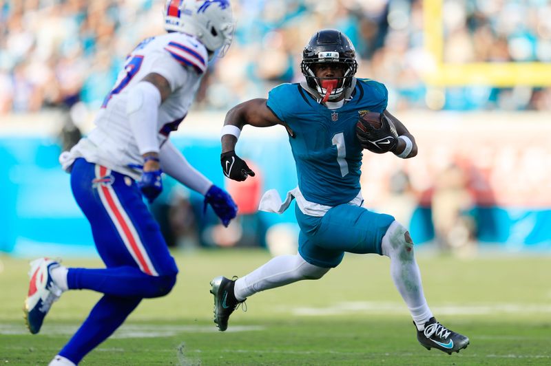 Jacksonville Jaguars running back Travis Etienne Jr. (1) rushes for yards against Buffalo Bills cornerback Christian Benford (47) during the fourth quarter of an NFL football AFC Wild Card playoff matchup, Sunday, Jan. 11, 2026, in Jacksonville, Fla. The Bills defeated the Jaguars 27-24. [Corey Perrine/Florida Times-Union]