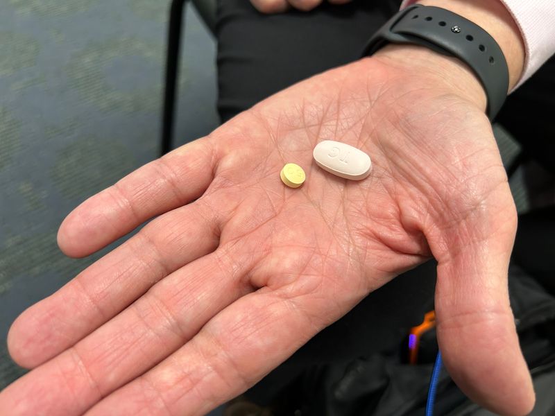 Michael Rajner holds the two pills he takes everyday to keep his HIV viral load undetectable at the Florida Capitol on Jan. 14, 2026.
