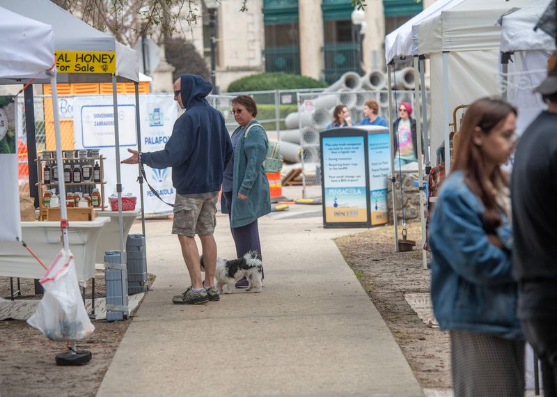 Shoppers browse around the boothes at Palafox Market Plaza Ferdinand VII Saturday, Jan. 17, 2026. Construction on Palafox has slowed down business at this location .