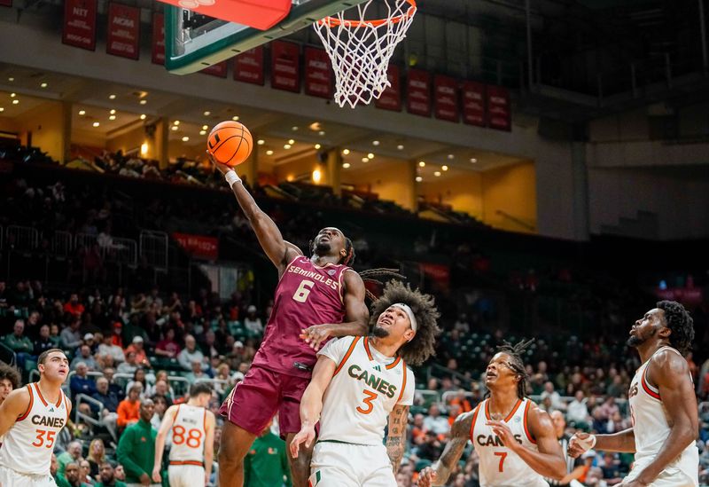 FSU basketball guard Robert McCray V makes a layup over Miami's Tre Donaldson in the Seminoles 65-63 win over the Hurricanes on Tuesday, Jan. 20 at the Watsco Center in Coral Gables.