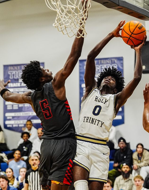 Omari Savage of Holy Trinity is challenged at the rim by Andrew Vassell, Jr of Palm Bay during their gamel January 20, 2026. Craig Bailey/FLORIDA TODAY via USA TODAY NETWORK