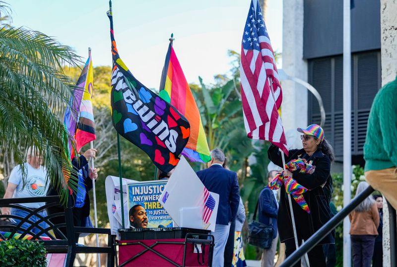 Naples Pride members gather their flags and signs after holding a rally before a city council meeting at Naples City Hall in Naples, Fla., on Wednesday, Jan. 21, 2026.