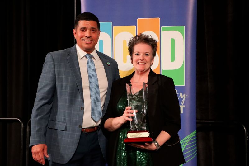 Okaloosa County School District Superintendent Marcus Chambers presents Kimberly Day-Scanlon with the 'Teacher of the Year' Award.