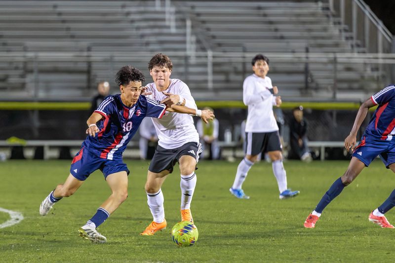 Centennial’s Joshua Hernandez (18) protects the ball from Vero Beach’s Callum Buck (11) during the District 8-7A boys soccer semifinal on Jan, 23, 2026, at South County Regional Stadium. Vero Beach won 1-0.
