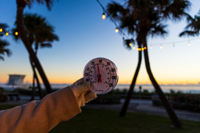 A woman holds up a thermometer that reads 31 degrees in Lake Worth Beach, Florida on February 1, 2026.