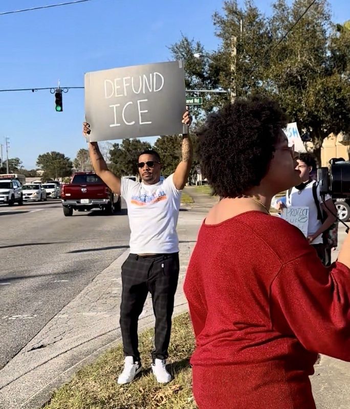 Ronnie Murchinson-Rivera, a Democrat running for U.S. House of Representatives in Florida's 6th District, holds a "DEFUND ICE" sign at a protest near Atlantic High School in Port Orange on Jan. 30, 2026.