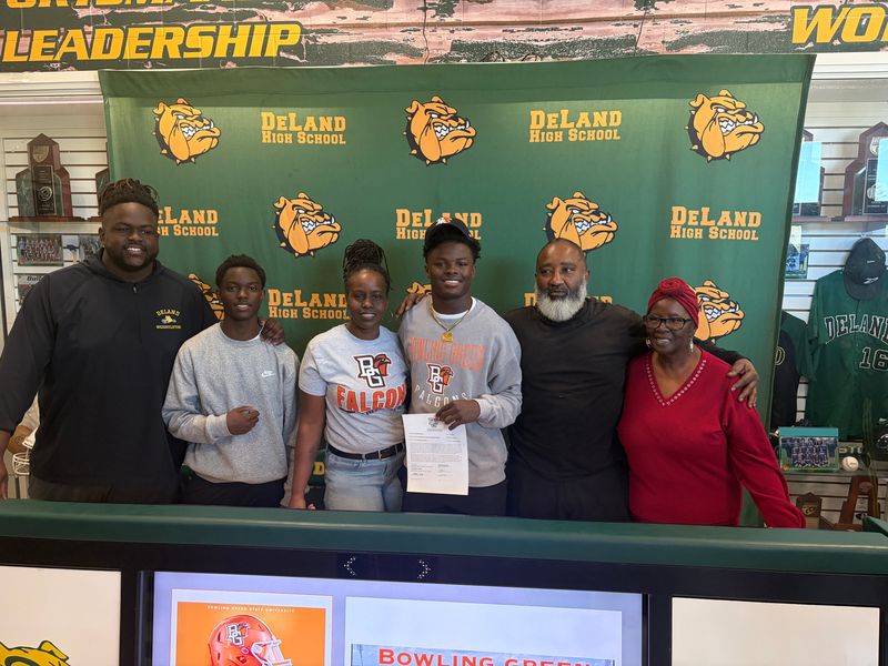 DeLand's Marceles Carey stands with his family members after signing with Bowling Green during National Signing Day, Wednesday, Feb. 4, 2026, at DeLand High School.