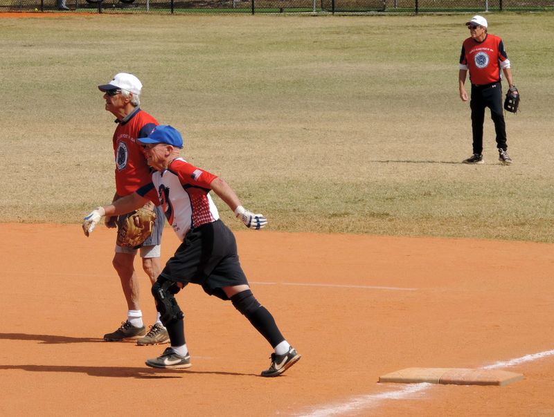 Crazy Flamingo’s John Sherwin heads for second base as American Legion first baseman Al Bozzo watches the action.