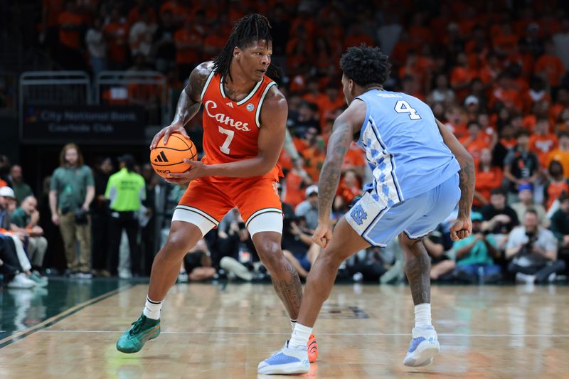 Feb 10, 2026; Coral Gables, Florida, USA; Miami Hurricanes forward Shelton Henderson (7) protects the basketball against North Carolina Tar Heels guard Jaydon Young (4) during the first half at Watsco Center. Mandatory Credit: Sam Navarro-Imagn Images