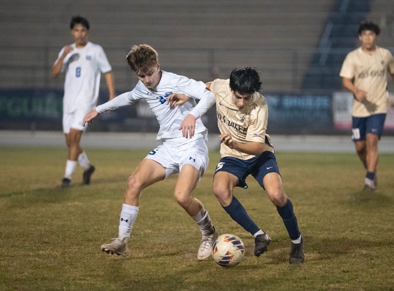 Wildcats Taylor Davies (25) and Dolphins Javier Torres (5) fight for the ball during the Booker T. Washington vs Gulf Breeze boys soccer 5A Region Semifinal game at Gulf Breeze High School on Feb. 12, 2026.
