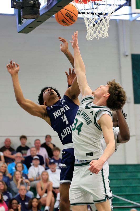 North Florida Ospreys guard Devin Hines (4) and Jacksonville Dolphins guard Evan Sterck (34) vie for a rebound during the second half of an NCAA men’s basketball game at Swisher Gymnasium, Saturday, Feb. 14, 2026, in Jacksonville, Fla. JU held off UNF 63-56. [Corey Perrine/Florida Times-Union]