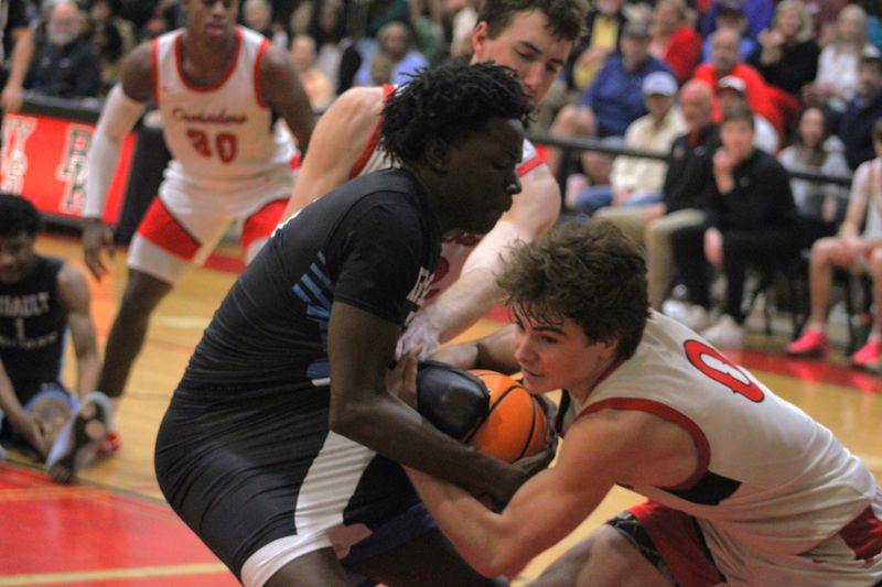 Ribault forward Stephen Odoms (5) battles for the ball with Bishop Kenny center Jack Lyons (32) and guard Drew Jackson (0) during Saturday's game.