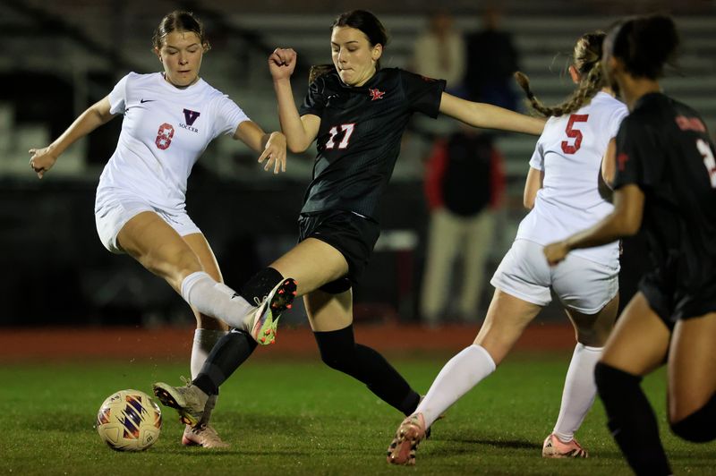 Vanguard's Kendal Davis (8) and Bishop Kenny's Louise Schwegel (17) vie for the ball during the second half of an FHSAA Region 1-4A high school girls soccer final at Bishop Kenny High School, Tuesday, Feb. 17, 2026, in Jacksonville, Fla. The Bishop Kenny Crusaders defeated the Vanguard Knights 5-1. [Corey Perrine/Florida Times-Union]