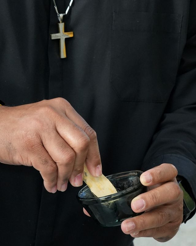 On Ash Wednesday, Pastor Carl Taylor stirs a bowl of ashes at Advent Lutheran Church in the Melbourne/Suntree area, where indoor, drive-up and walk-up options for prayers, support and ashes were offered.