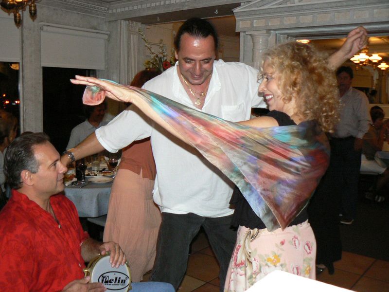 Bradenton resident Stamatis Zeris, left, plays a mini drum and Sarasota residents Dimitri Trovas, middle, and Marsha "Ace" Kramer, right, dance together at El Greco Cafe's Greek Night.